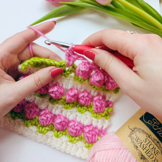 Person crocheting tulip design crochet square