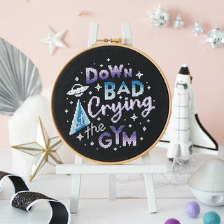 Space themed cross stitch project on black fabric