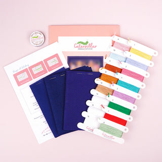 Gingerbread Lane Stitch-a-long standard kit supplies showing three fabric options and thread wax