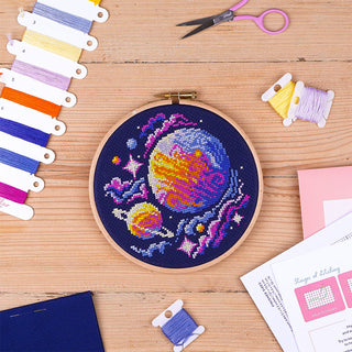 Out of this World Cross Stitch Kit - Stitched sample in 6inch Elbesee hoop flatlay on wooded table