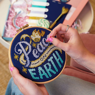 Peace on Earth Cross Stitch Sample in Hand