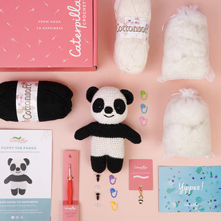 Poppy the Panda finished project, kit supplies and stitch marker flat lay